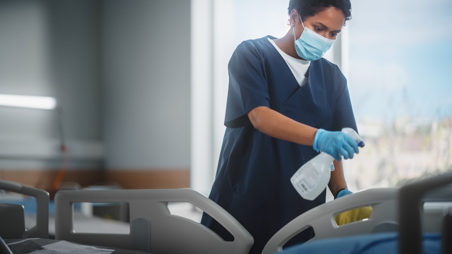 Professional medical cleaning services staff in Singapore disinfecting a hospital ward to ensure patient safety and MOH compliance.